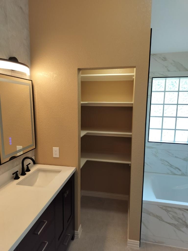 New vanity with a sleek design and custom shelving in the closet to maximize storage space.
