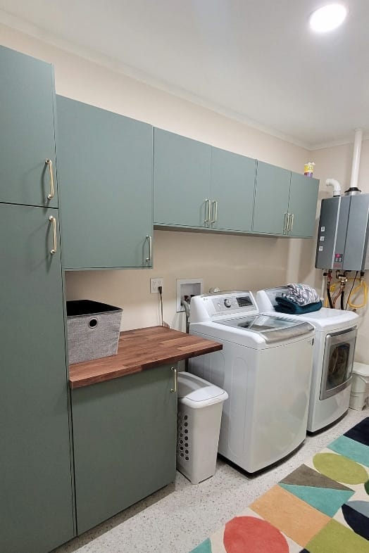 Modern laundry room reno with new cabinets, flooring, lighting, countertop, and an upgraded water heater.