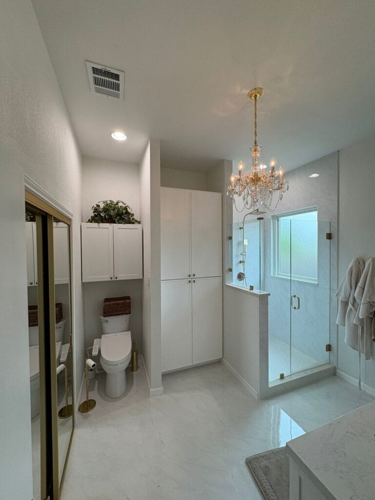 Spacious bathroom with glass walk-in shower and custom storage cabinets