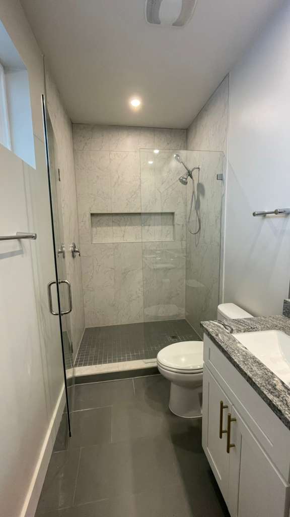 Before: Bathroom before remodel showing dated light tile and old flooring needing replacement