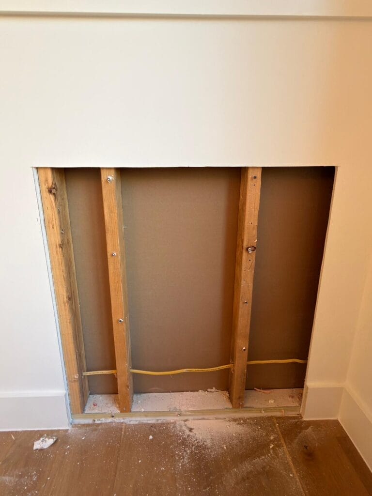 Construction view showing framed opening in wall under staircase during build